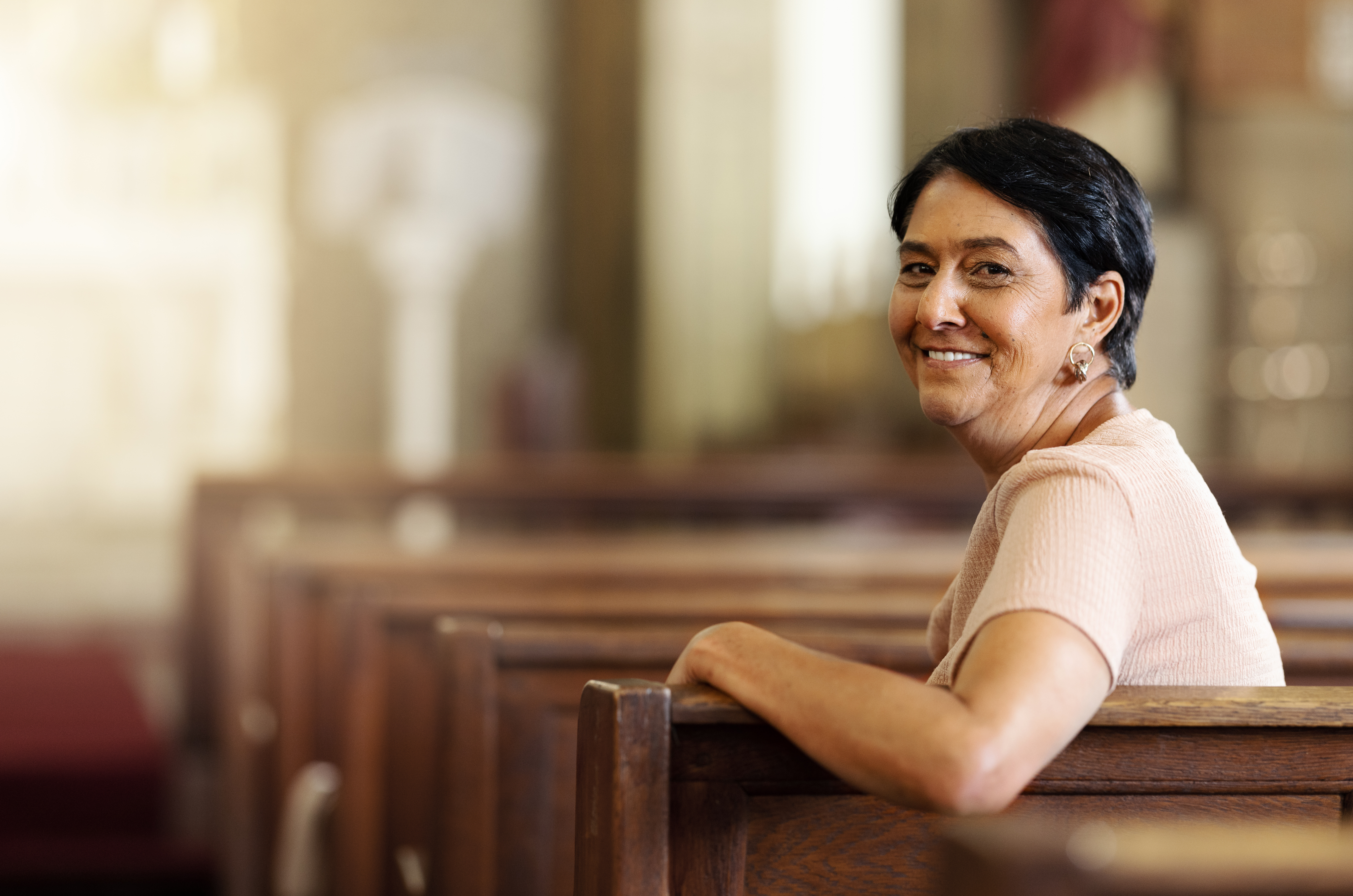 Senior woman, christian and happy in church, spiritual and religion after service, smile and lifestyle. Elderly female smile, portrait and empowerment while sitting in wood bench in catholic chapel Jean, donateur
