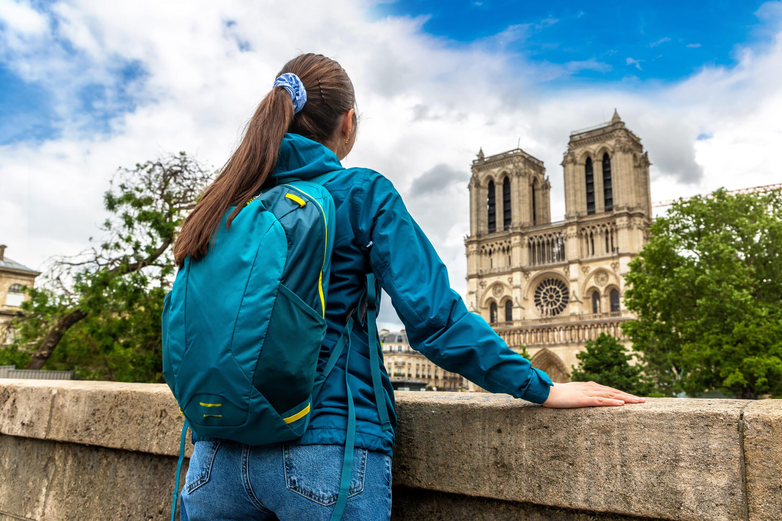 Woman traveler at Notre Dame de Paris is the one of the most famous symbols of Paris, France jeune fille qui prie